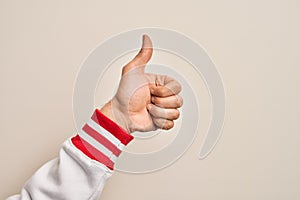 Hand of caucasian young man showing fingers over isolated white background doing successful approval gesture with thumbs up,