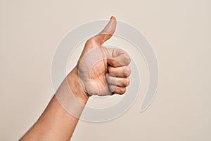 Hand of caucasian young man showing fingers over isolated white background doing successful approval gesture with thumbs up,