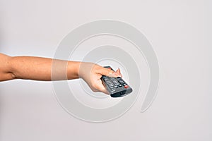 Hand of caucasian young woman changing television channel holding tv remote control over isolated white background