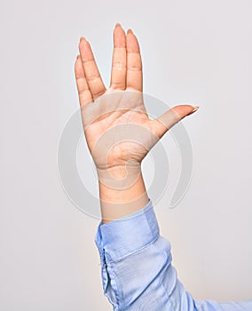 Hand of caucasian young woman doing freaky star trek salutation over isolated white background