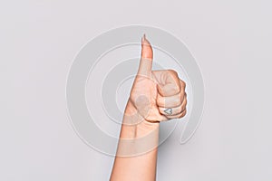 Hand of caucasian young woman doing successful approval gesture with thumbs up, validation and positive symbol