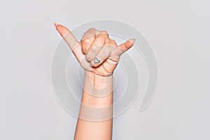 Hand of caucasian young woman gesturing Hawaiian shaka greeting gesture, telephone and communication symbol