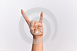 Hand of caucasian young woman gesturing rock and roll symbol, showing obscene horns gesture