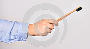 Hand of caucasian young woman holding toothbrush over isolated white background