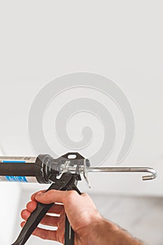 Hand with caulking gun with copyspace on top