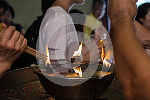 Hand cense joss stick to at an incense burne