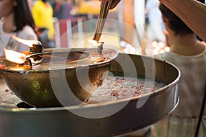 Hand cense joss stick to at an incense burne