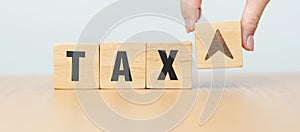 hand change wooden block with TAX text to UP and Down arrow icon. decrease and Increase, Taxpayer, Taxable Income, Tax Filing,