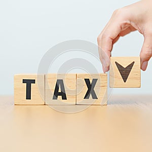 hand change wooden block with TAX text to UP and Down arrow icon. decrease and Increase, Taxpayer, Taxable Income, Tax Filing,