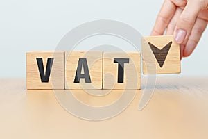 hand change wooden block with VAT text to UP and Down arrow icon. Value Added Tax, decrease and Increase, Taxpayer, Taxable Income