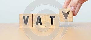 hand change wooden block with VAT text to UP and Down arrow icon. Value Added Tax, decrease and Increase, Taxpayer, Taxable Income