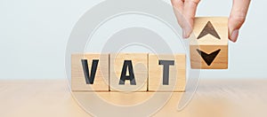 hand change wooden block with VAT text to UP and Down arrow icon. Value Added Tax, decrease and Increase, Taxpayer, Taxable Income