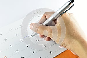 Hand checking meeting plan in calendar.