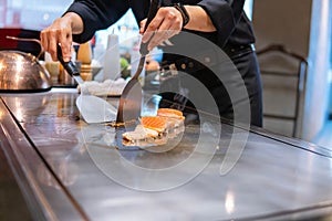 Hand of Chef cooking salmon steak