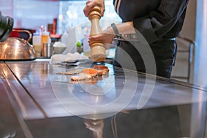 Hand of Chef cooking salmon steak