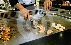 Hand of Chef cooking salmon steak