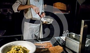 Hand of Chef cooking spagetti on hot pan