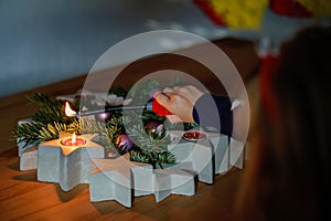 Hand of child lighting a candle on advent wreath on Christmas eve or first advent. Tradtional wreath in Germany. Happy