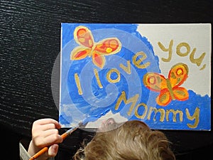 hand of a child painting a picture for mommy