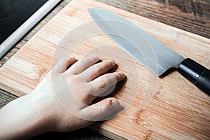 Hand Of A Child Reaches Sharp Kitchen Knife On A Chopping Board - Prevent Child Hazard Concept