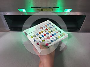 Hand of a child returning a book into an automated book return machine