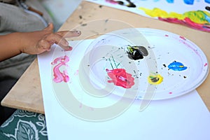 The hand of a child who paints with tempera