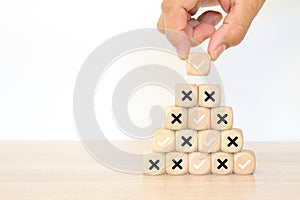 Hand choose check mark with cross symbol on cube wooden block stack for true or false changing mindset or way of adapting to