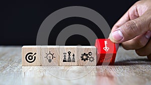 Hand choose cube wooden block stack with the key on business strategy icon with graph and arrow bullseye of strategic plan and mar