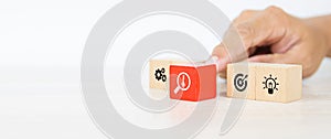 Hand choose cube wooden block stack with the key on business strategy icon with graph and arrow bullseye of strategic plan and mar