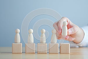 Hand Choose figure standing out from the group of crowd. Business hiring and recruitment selection concept.