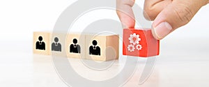 Hand choose gear icon on cube wooden toy block stack with people icon for business team