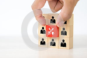 Hand choose key with cube wooden block toy stack with human icon for goal of people business team