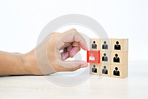 Hand choosing people icon with head light bulb on cube wooden toy block stacked.