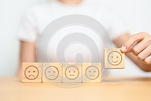 Hand choosing smile face from Emotion block for customer review, good experience, positive feedback, satisfaction, survey,