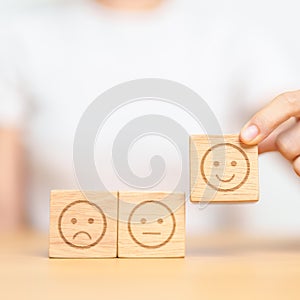 Hand choosing smile face from Emotion block for customer review, good experience, positive feedback, satisfaction, survey,