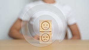 Hand choosing smile face from Emotion block for customer review, good experience, positive feedback, satisfaction, survey,