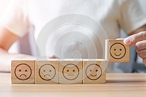 Hand choosing smile face from Emotion block.  customer review, good experience, positive feedback, satisfaction, survey, rating