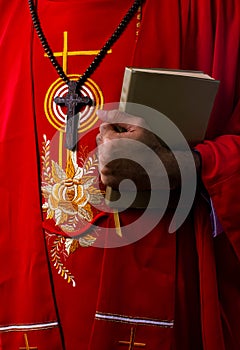 Hand of christian priest holding holy bible