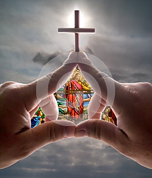 Hand church with cross stained glass against sky