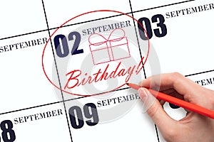 The hand circles the date on the calendar 2 September , draws a gift box and writes the text Birthday. Holiday.