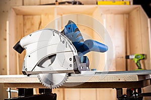 Hand circular saw with piece of wood on workbench. closeup sawing machine woodworking construction tool concept furniture making