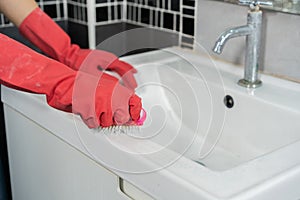 Hand cleaning bathroom sink with brush