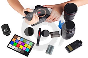 Hand cleaning a camera with cloth and photography equipment on white table. with clipping path