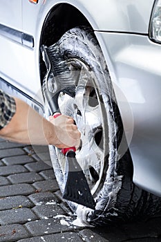 Hand cleaning car wheel