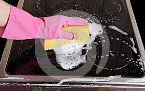 Hand cleaning cooktop.