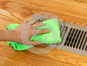 Hand Cleaning Grill Plate of Floor Heating Vent in Home