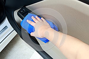 Hand cleaning interior car door panel with microfiber cloth