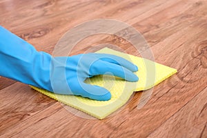 A hand cleaning a parquet floor