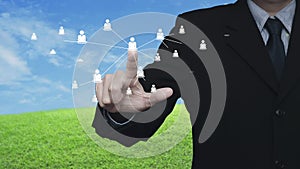 Hand click businessman icon with connection line over green grass field with blue sky, Business communication concept