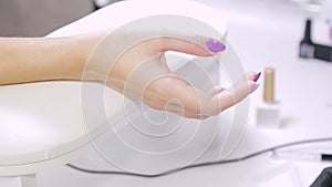 Hand of a client of a beauty salon with manicure gel polish.